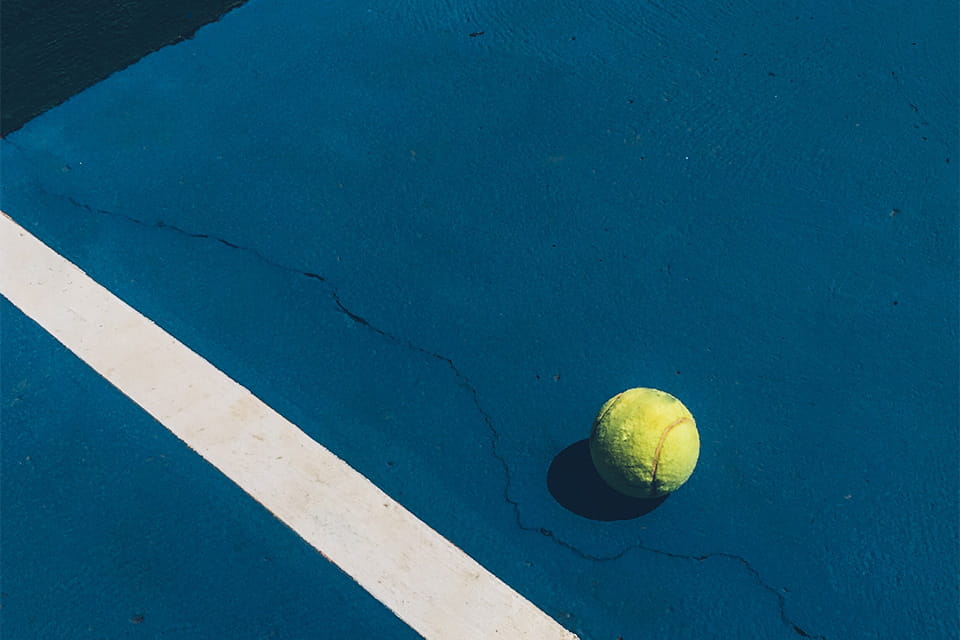 Мяч для тенниса на теннисном корте синего цвета